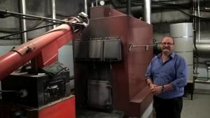 Ara Timaru Facilities Manager Roger Luscombe with the wood boiler that heats the campus and reduces CO2 emissions.
