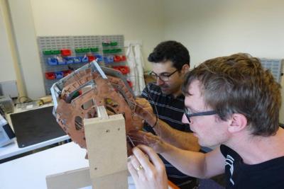 Ben Parkinson (right) and Konstantinos Bouloukakis working on a helmet-style MRI magnet (half-scale version), developed as part of the KiwiNet Emerging Innovator Programme